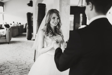 Naklejka premium Bride smiles while groom holds her arms tenderly