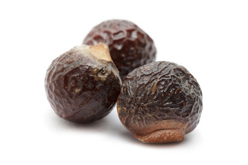 Organic Chinese soapberry or Reetha (Sapindus mukorossi) seeds. Isolated on white background. Macro close up. Top view.