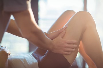 Physiotherapist giving leg massage to a woman