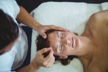 Obraz na płótnie Canvas Woman receiving head massage from physiotherapist