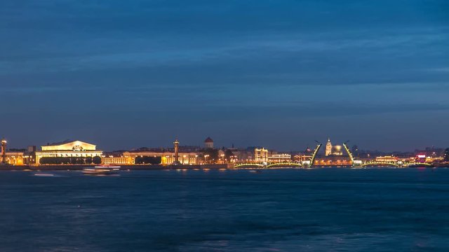 Night view of spit of Vasilyevsky Island and opened Birzhevoy Bridge with rostral column timelapse, Saint Petersburg, Russia.