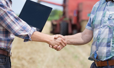 Shaking hands on farmland