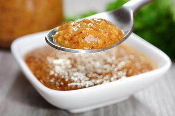 Schale mit Senf oder Mostert vor Senfglas und Petersilie 