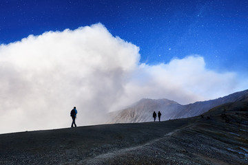 Group of tourists is on the edge of the crater in early morning