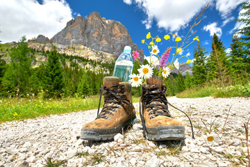 Wanderschuhe mit Wasserflasche und Blumen, Wandern in den Bergen