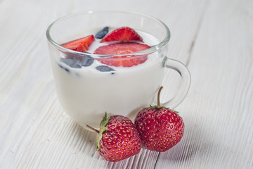 Milk fruit dessert with red strawberries in a cup.