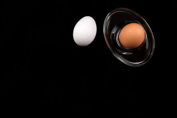 Eggs on black background, top view
