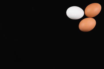 Eggs on black background, top view