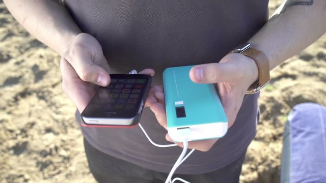 The young man with gadget to charge your smartphone