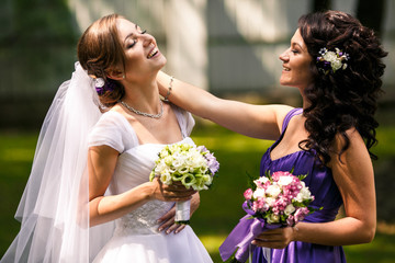 Bride and bridesmaid look adorable preparing to the ceremony