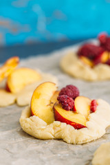 Delicious ready for baking mini tarts with fresh berries and fruits on food lattice