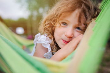 Fototapeta na wymiar happy child girl relaxing in hammock in summer forest, summer camp, traveling on vacations