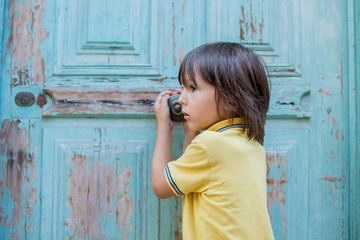 Fototapeta premium Portrait of boy, standing in front color door