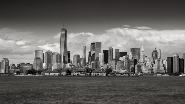 Black & White time lapse of New York City’s Financial District skyscrapers and clouds with Ellis Island from New York harbor