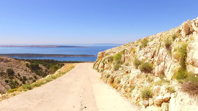 On the dusty and warm path on island of Rab, Croatia, Europe. Hot summer day to walk in the middle of deserted island.