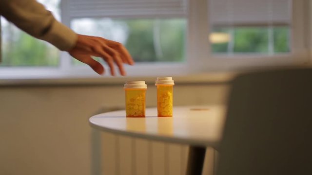 Man takes a bottle of pills on the table