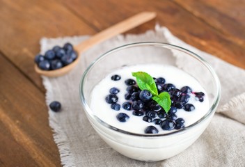 Homemade yogurt with fresh blueberries on a wooden table