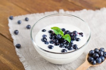 Homemade yogurt with fresh blueberries on a wooden table