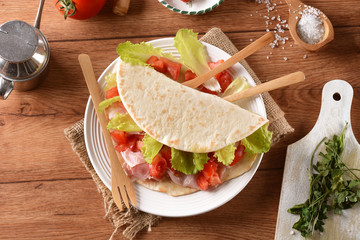 piadina romagnola con prosciutto, pomodoro e verdura - trazionale cibo italiano