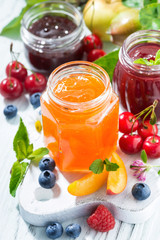 assortment of jams and seasonal fruits, vertical top view