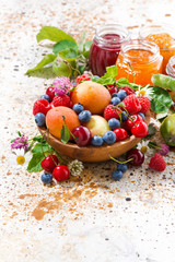 assortment of seasonal fruits and berries, jams on table