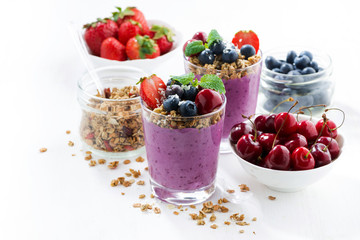 Blueberry dessert with granola in glass on a white background