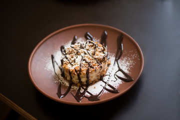 Picture of vegan dish represented on wooden plate. Sweet meal is being served in vegan restaurant or cafe. Healthy food.