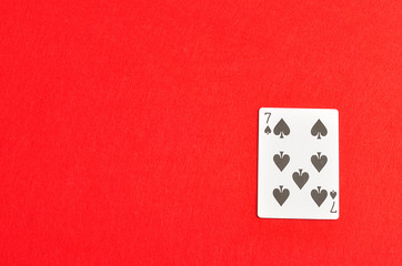 Playing card. Seven of spades isolated on a red background