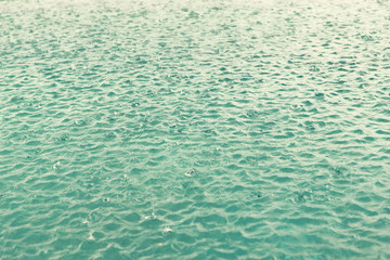 water surface with raindrops at rainy day