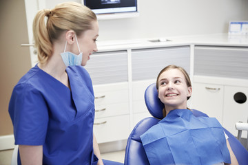 happy female dentist with patient girl at clinic