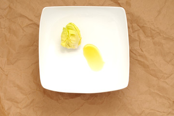 concetto di dieta, un cuore di insalata cappuccina e olio d'oliva extra vergine, in un piatto quadrato, vista dall'alto