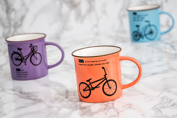 Colorful Modern Ceramic Mugs on White Marble Background	