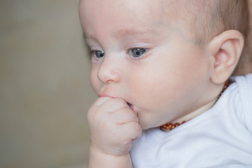 Baby boy holding hand in his mouth 