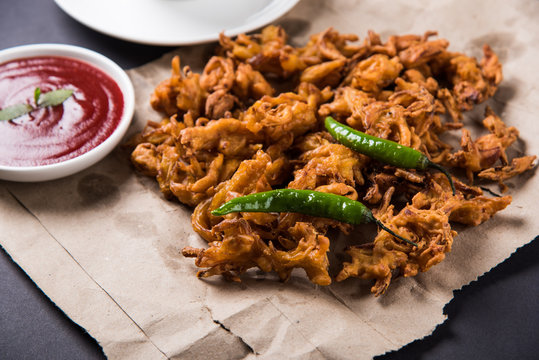 Crispy onion bhaji or kanda bhaji or fried onion pakore or pakode, delicious street food, favourite indian snack in monsoon served with hot tea