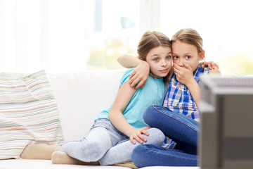 scared little girls watching horror on tv at home