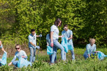 volunteers with garbage bags cleaning park area