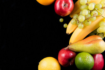 Fresh fruits on black background, top view