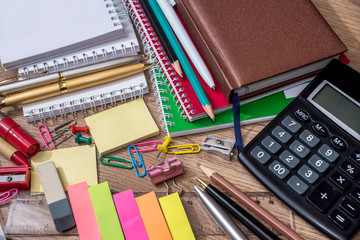 many school supplies on wooden background