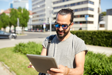 man traveling with backpack and tablet pc in city