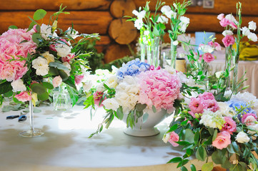 Florist workspace for decorating wedding reception at restaurant with flowers, accessories, vases