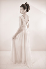 Fototapeta na wymiar Black And White Studio Shot Of Sensual Elegant Bride With Classic Hairstyle Posing In Beautiful Wedding Dress