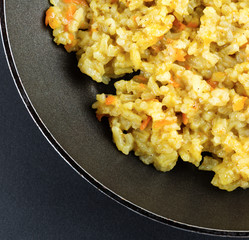 Boiled rice in a frying pan on a black