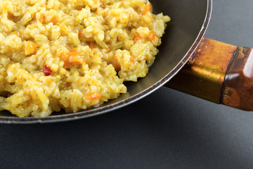 Boiled rice in a frying pan on a black