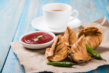Samosa snack with tomato ketchup and hot tea, Fresh samosas with ketchup and hot chai ready for...