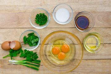 Raw eggs and ingredients on  wooden background. Vegetarian food, health or cooking concept.