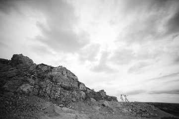 Pregnant woman and man photo shoot in a stone quarry