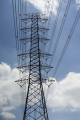 electricity transmission lines and pylon silhouetted against blue sky and cloud,high voltage tower