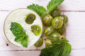 Smoothie in a glass and fresh gooseberries