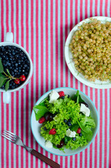 Healthy vegetarian salad with berries in a bowl in a rustic style