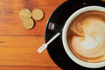 cup of coffee on the table and coins